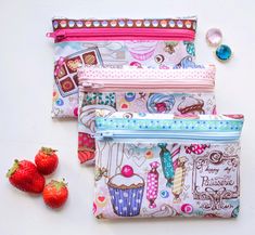 three zippered pouches with strawberries on the side