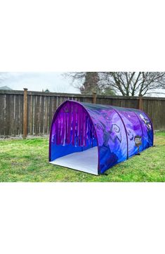 a purple and blue tent sitting in the grass