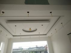 the ceiling in this room is being painted white and has holes on it that are hanging from the ceiling