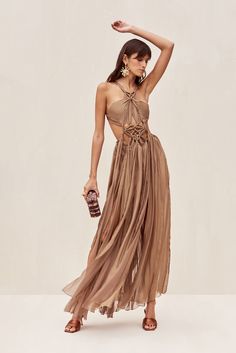 The Alexa Gown features signature Cult Gaia cutouts created from the binding of her silk fabric with gold-toned, brushed brass rings. Back straps featuring sliders and hook-and-eye closures allow for a customizable fit. A ribbon tie at the back waist adds more adjustability. Ribbons of silk are folded and bound along the waistline to create the long skirt. Wider bands at the waist provide coverage. High slits give graceful movement and allure the length of this dress. Grecian Gown, Bronze Dress, Gown Gold, Gold Gown, Brass Rings, Halter Gown, Cult Gaia, Ribbon Tie, Gold Dress