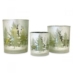 three glass cups with deer and trees painted on the sides, one has a green tint