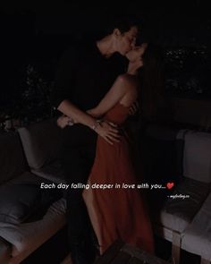 a man and woman kissing in front of a couch with the caption each day falling deeper in love with you