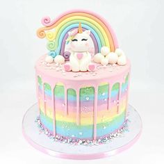 there is a cake decorated with rainbows and a unicorn on it's side