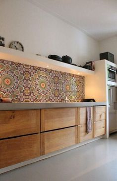 a kitchen with wooden cabinets and a clock on the wall above it's counter