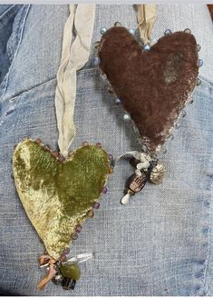 two heart shaped brooches hanging from the back of someone's jean pants