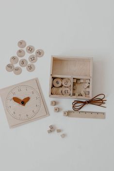 a wooden box with numbers and magnets next to a clock