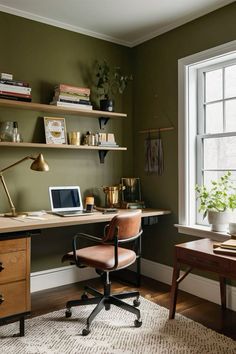 a home office with green walls and wooden desk, chair, bookshelf and window