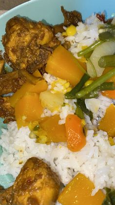 a blue bowl filled with rice and vegetables