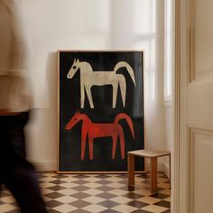 a black and white horse painting next to a red horse on a checkered floor