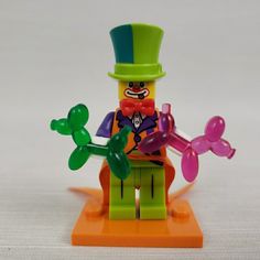 there is a lego man with balloons in his hand and a top hat on it