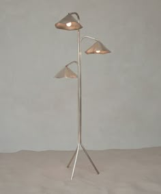 three light floor lamp with two lamps on each side and one in the middle, against a gray background