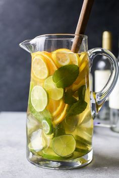 a pitcher filled with lemon slices and limes