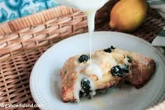 a white plate topped with blueberry cheesecake next to a basket filled with lemons