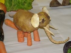 an elephant made out of carrots and broccoli sitting on top of a table