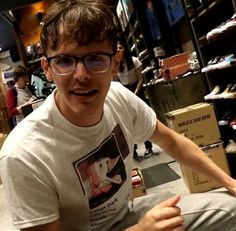 a man sitting on the floor in front of shoes