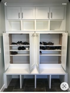 an empty walk in closet with white shelves and black shoes on the bottom shelfs