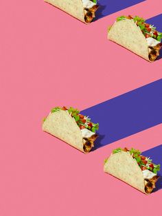 three tacos on pink and blue striped background