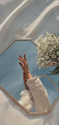 a woman's reflection in a mirror next to flowers