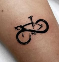 a black ink bicycle tattoo on the leg