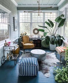 a living room filled with furniture and lots of plants