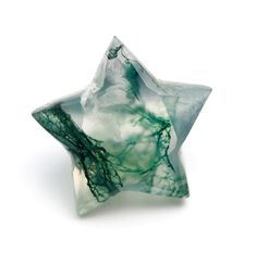 a green and white star shaped object on a white surface