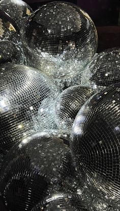 many shiny disco balls are piled on top of each other