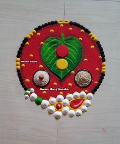 a round cake decorated with different types of food on top of a wooden table next to a white wall