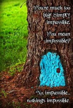 a tree trunk with a blue door in it and a quote written on the bark