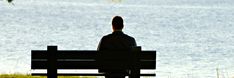 a person sitting on a bench looking out over the water