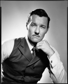 a black and white photo of a man adjusting his tie