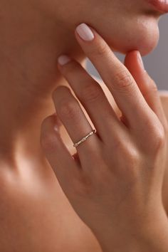 a woman with her hand on her neck wearing a diamond ring