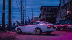 an old car is parked on the side of the road in front of some buildings