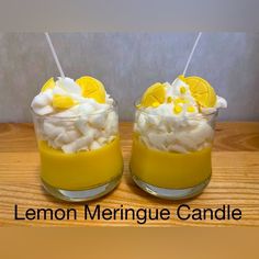 two glasses filled with lemon meringue and marshmallows on top of a wooden table