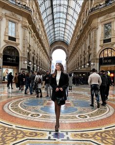 a woman is walking through the middle of a shopping mall