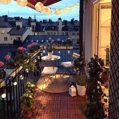 an outdoor patio with potted plants and lights