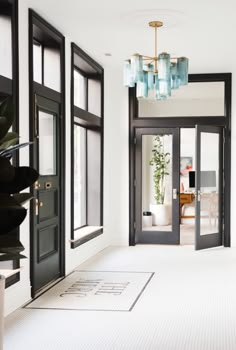 an empty room with black doors and chandelier