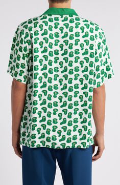 Broadcast your love for the game on or off the course in this drapey shirt printed with flags. Front button closure Notched collar Short sleeves 100% rayon Dry clean Imported Green Collared Shirt With All Over Print, Green Top With All Over Print And Camp Collar, Green Collared Top With All Over Print, Green Short Sleeve Shirt With All Over Print, Green Short Sleeve Shirt With Graphic Print, Relaxed Fit, Collared Golf Tops For Summer, Green Relaxed Fit Short Sleeve Shirt With Graphic Print, Green Printed Tops With Camp Collar, Green Printed Top With Camp Collar