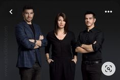 two men and a woman standing in front of a black background with their arms crossed