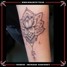 a black and white photo of a lotus flower tattoo on the left arm, with an arrow in the middle