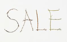 the word sale spelled out with twigs in front of a white background that says sale