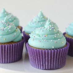 there are frosted cupcakes with blue icing and sprinkles on them