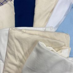 a pile of white and blue sheets sitting on top of each other