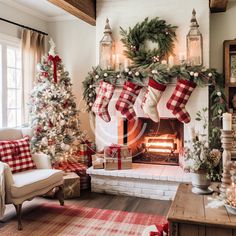 a living room decorated for christmas with stockings on the fireplace