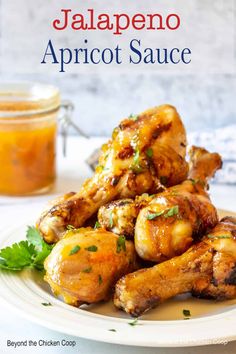 chicken wings with jalapeno apricot sauce on a white plate next to a jar of jam