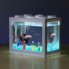 there is a lego fish in the box with its lights on and some water inside