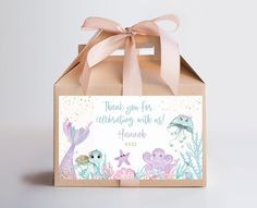 a gift bag with an under the sea theme on it and a pink ribbon tied around it