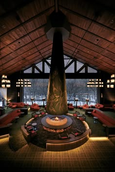 the inside of a restaurant with tables, couches and a fire place in it