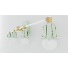 two light fixtures on a white wall with green shades and gold accents, one is shaped like an angel's wings