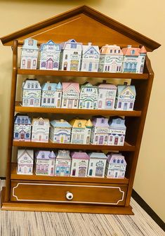 a wooden shelf filled with lots of little houses