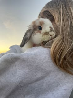 a woman holding a small rabbit in her arms